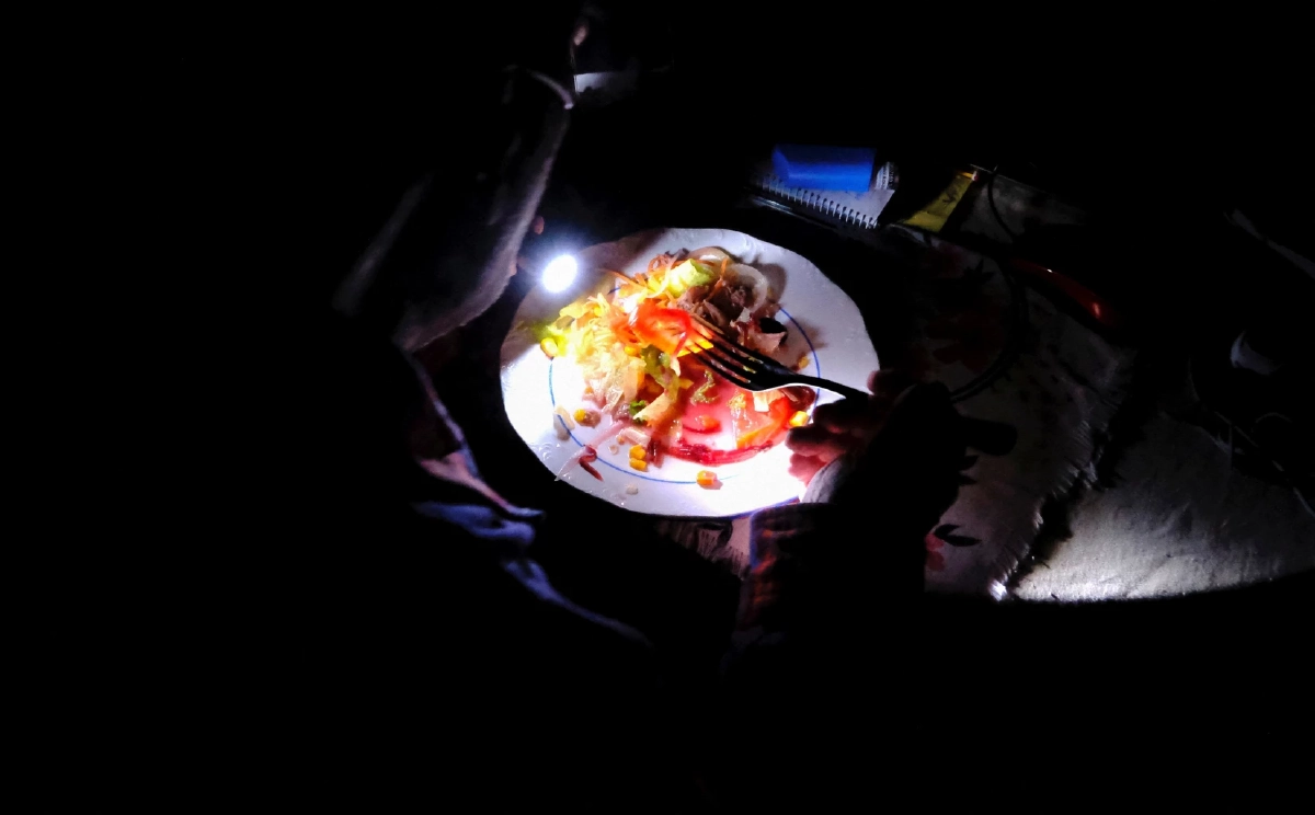 นั่งทานข้าวใต้แสงไฟฉาย ในวันไร้ไฟฟ้า ในบาเซโลนา สเปน Cr. Reuters