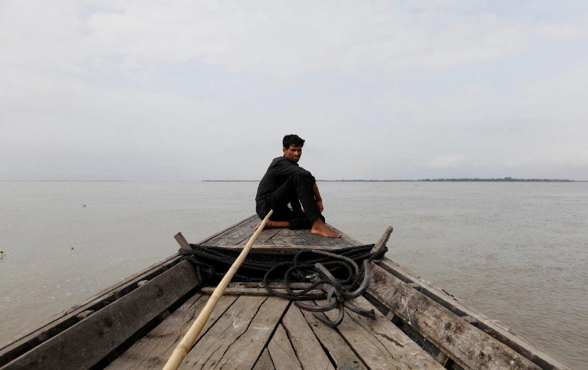 ชายนั่งบนหัวเรือ ในแม่น้ำพรหมบุตร แม่น้ำสายสำคัญของอินเดียที่เชื่อมต่อมาจากยาร์ลุงซางโปของทิเบต Cr.Reuters