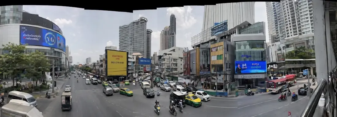 Prompt: create a photorealistic panorama shot as if taken on iphone of a busy asian city. make it a bit jaggedy like my hand shook while taking the panorama shot ; there should be fault lines where the image