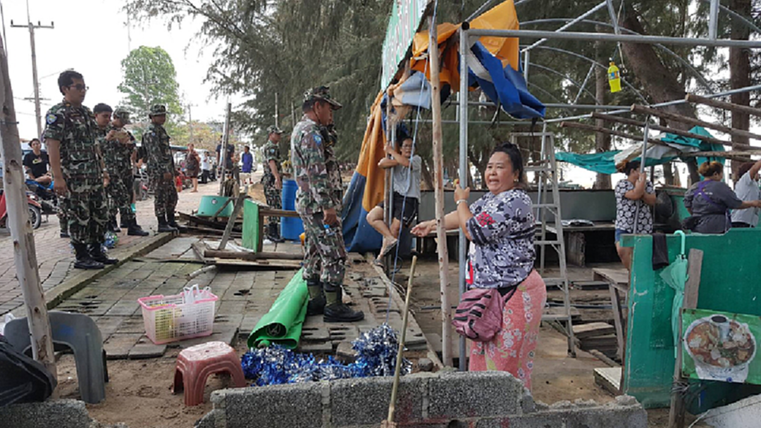 รื้อถอนเพิงร้านค้าริมชายหาดแม่รำพึง เจอหญิงกอดเสาขวางจนท.